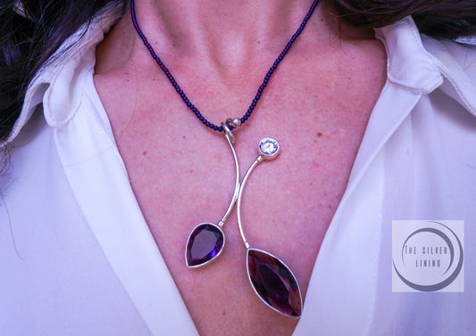 Gargantilla de Perlitas Tornasol Moradas con Dije de Hojas Otoñales Moradas con sus juego de Aretes en Cristal Morado